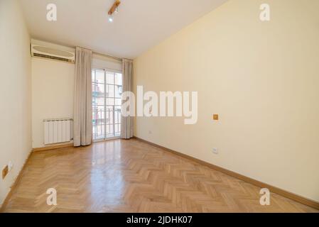 Chambre vide avec balcon avec rideaux blancs et portes coulissantes en aluminium et verre, radiateur en aluminium et climatiseur Banque D'Images