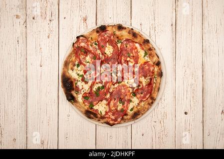 Pizza Diavola avec mozzarella et persil frais haché cuite dans un four à pierre Banque D'Images