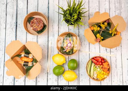 Ensemble de plats asiatiques sains, avec un bol de saumon, nigiri, bandillas épicés, tartare de thon rouge, ceviche à l'oignon rouge, citrons et limes Banque D'Images