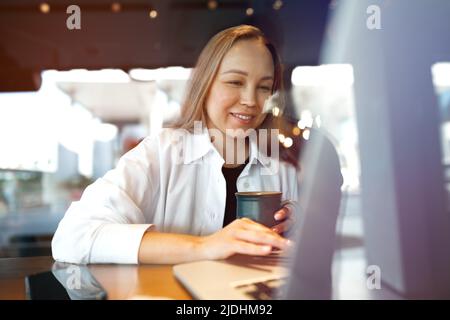 Portrait d'une jeune femme d'affaires qui boit du café au café Banque D'Images