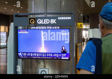 Séoul, Corée du Sud. 21st juin 2022. Un homme regarde le lancement d'une fusée spatiale par la télévision à la station de Yongsan à Séoul, en Corée du Sud, au 21 juin 2022. La Corée du Sud a lancé avec succès mardi sa fusée spatiale maison, plaçant plusieurs satellites dans l'orbite basse de la Terre. Crédit : Wang Yiliang/Xinhua/Alay Live News Banque D'Images