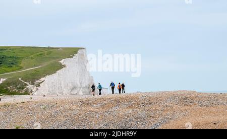 Seaford juin 2022 - Walkers Profitez d'une journée chaude mais couvert à Cuckmere Haven par les célèbres falaises de Seven Sisters près de Seaford dans East Sussex sur le solstice d'été comme temps chaud est prévu pour les prochains jours : Credit Simon Dack / Alamy Live News Banque D'Images