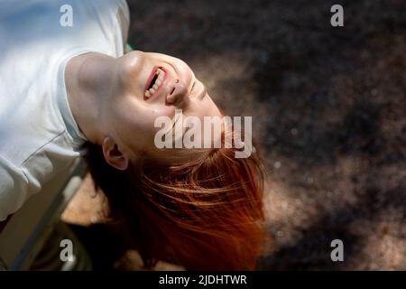 Portrait d'une fille joyeuse riant avec de longs cheveux sur fond de nature. Photo de haute qualité Banque D'Images