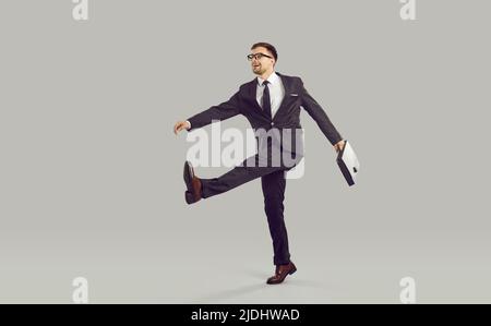 Homme d'affaires avec mallette et expression folle ridiculement va au travail dans le bureau de l'entreprise. Banque D'Images