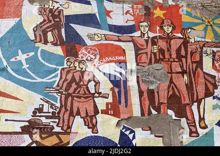 Mosaïque soviétique avec soldats, armée, avion, char et drapeaux sur un bâtiment près de motopark à Rustavi, Géorgie Banque D'Images