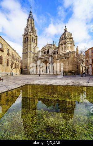 Cathédrale de Tolède avec des reflets dans l'eau sur le sol, par une journée ensoleillée avec des nuages. Espagne. Banque D'Images