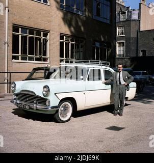 1964, historique, un gentleman dans un costume et une cravate, fièrement debout par sa voiture de l'époque, un ton, British Ford Zodiac, bureaux extérieurs de Babcock & Wilcock Ltd, Angleterre, Royaume-Uni. Banque D'Images