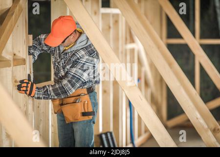 Construire le cadre du bâtiment en bois. Travailleur de la construction professionnel qui pose les éléments en bois. Construction de maisons résidentielles en bois SIT Banque D'Images