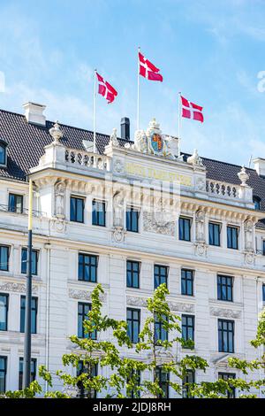 Drapeaux danois survolant l'hôtel d'Angleterre de 1755 à Kongens Nytorv (la nouvelle place du roi) à Copenhague, Danemark. Banque D'Images