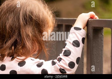 Petite fille aux cheveux rouges tenant un tourniquet dans un parc d'été Banque D'Images