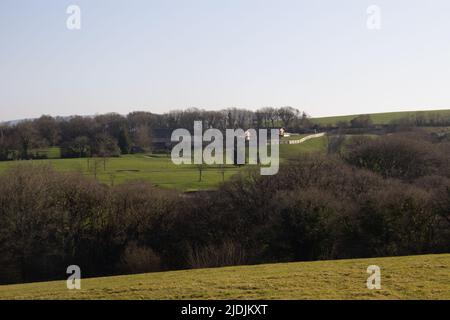 Ferme typique du Nord Devon avec champs, haies et un terrain de golf en arrière-plan Banque D'Images