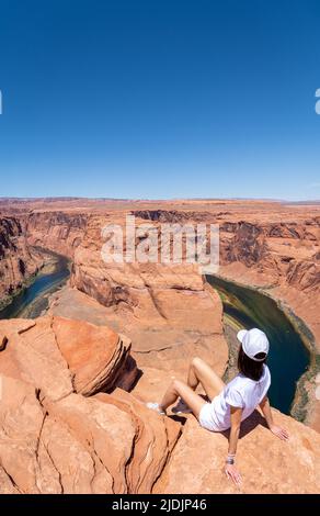 Une fille inconnue avec des vêtements blancs à Horseshoe Bend à page, Arizona, par une journée ensoleillée Banque D'Images