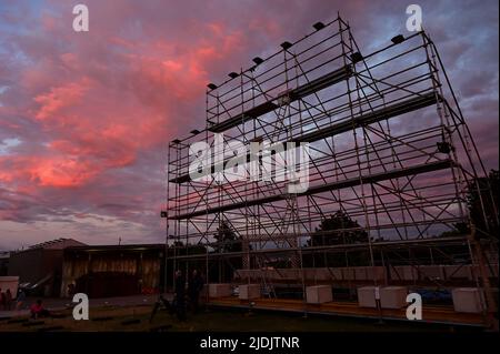 21 juin 2022, Hessen, Kassel: Baigné de lumière rougeâtre par le soleil, un nuage est à côté de l'échafaudage vide sur lequel la grande bannière controversée "Justice du peuple" par l'artiste indonésien collectif Taring Padi avait précédemment accroché. L'installation très critiquée de documenta Fifteen à Kassel a été enveloppée la veille. Suite aux critiques de l'opinion publique pour son contenu, qui a été critiqué comme antisémite, l'œuvre a été retirée. Photo: Uwe Zucchi/dpa - ATTENTION: Seulement pour usage éditorial dans le cadre d'un rapport sur documenta 15 et seulement avec mention complète du crédit ci-dessus Banque D'Images