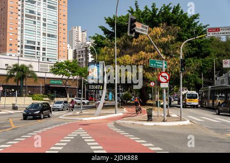 Vue sur le croisement de l'avenue Sumare avec la rue Joao Ramalho dans un jour d'affaires normal avec une piste cyclable fonctionnant au milieu sous le ciel bleu ensoleillé. Banque D'Images