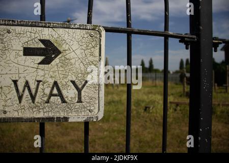 Détail de LA VOIE fissurée et ancien bord d'angle d'un panneau directionnel avec flèche pointant vers la droite Banque D'Images