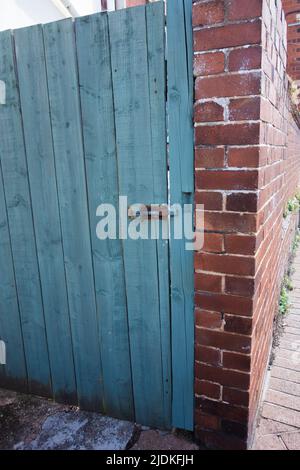 ancienne porte en bois avec boulon rouillé dans un nouveau mur en brique Banque D'Images