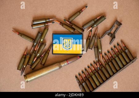 Pili se trouve sur un fond en bois et à côté se trouve un timbre avec le drapeau de l'Ukraine, la guerre en Ukraine, les munitions et les armes Banque D'Images