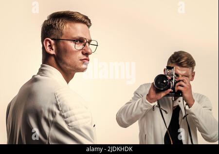 les deux frères hommes se ressemblent utilisent un appareil photo vintage pour photographier Banque D'Images
