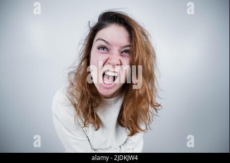Portrait en gros plan d'une femme aliénée en blouson sur fond blanc. Banque D'Images