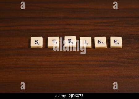 Gros plan sélectif de Strike Word. Fait en utilisant les lettres en blocs dans un fond en bois. Banque D'Images