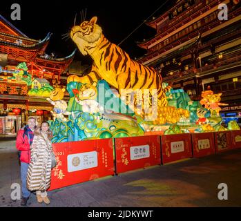 Un couple pose devant l'exposition de la lanterne de tigre à l'intérieur de Yu Yuan, Yu Garden, pendant le festival de lanterne de l'année du tigre. Banque D'Images