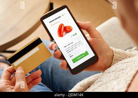 Gros plan sur une femme âgée qui commande des articles d'épicerie en ligne avec un téléphone intelligent. Banque D'Images