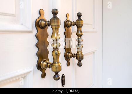 Poignée de porte longue élégante sur porte blanche en bois Banque D'Images