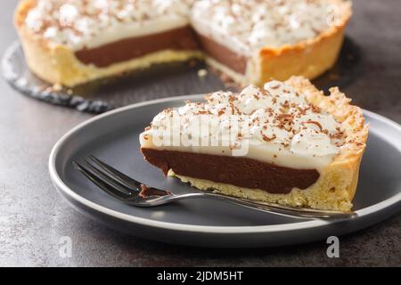 Haupia à la noix de coco et tarte au chocolat nappée de crème fouettée dans l'assiette sur la table. Horizontale Banque D'Images