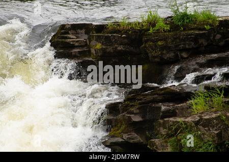 Eau en cascade sur des rochers aux chutes de Clyde, Lanark, Écosse Banque D'Images