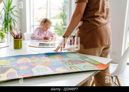 Enseignante mature parlant avec ses élèves pendant la classe à l'intérieur de l'école d'art Banque D'Images