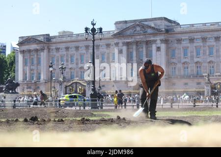 Un jardinier détourne le sol à l'extérieur de Buckingham Palace à Londres. Date de la photo: Mercredi 22 juin 2022. Banque D'Images