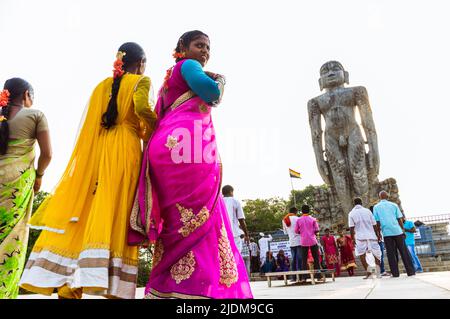 Dharmasthala, Karnataka, Inde : les femmes dans les saris colorés marchent vers la statue monolithique de Bahubali (Gomateshwara) de 12 m de haut à Ratnagiri Hill. Banque D'Images