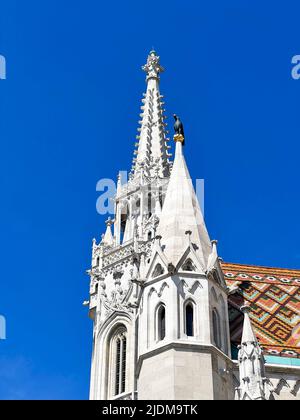 Corbeau tenant un anneau d'or sur une flèche de l'église Matthias tour au coeur du quartier du château de Buda à Budapest, Hongrie Banque D'Images