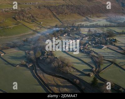 Un tir de drone montre la brume matinale et la fumée d'un flotteur de cheminée au-dessus du village de yorkshire Dales d'arncliffe Banque D'Images