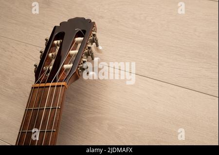 Le fretboard et la machine de guitare classique se dirigent de près sur un fond en bois clair avec un espace de copie Banque D'Images