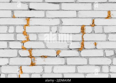 Vieux mur de briques blanc craquelé mousse de polyuréthane ou de mousse de construction réparation et reconstruction de la façade du bâtiment. Banque D'Images