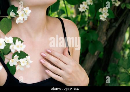 Crop femme parmi les fleurs de jasmin dans le jardin Banque D'Images