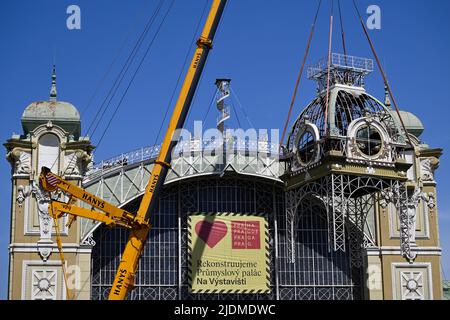 Des ouvriers, avec l'aide de grues, descendent le clocher depuis le toit du Palais industriel reconstruit sur le parc des expositions de Prague, à 22 juin 2022. La structure de la tour est en mauvais état et ne peut pas être réparée à son emplacement d'origine. Le Palais industriel a brûlé en 2008. Le coût de la reconstruction sera d'environ 2,64 milliards de couronnes tchèques, qui seront achevées en 2024. Les travaux seront réalisés par le consortium Société pour le Palais industriel dirigé par Metrostav. Des difficultés à long terme ont accompagné les efforts d'achèvement. (CTK photo/Ondrej Deml) Banque D'Images