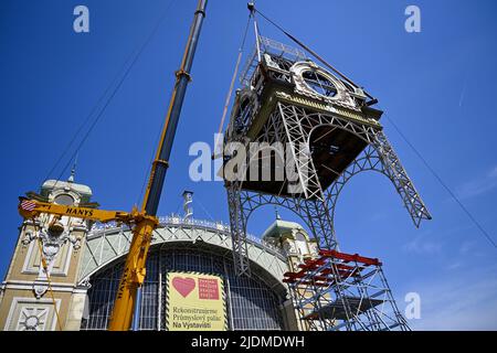 Des ouvriers, avec l'aide de grues, descendent le clocher depuis le toit du Palais industriel reconstruit sur le parc des expositions de Prague, à 22 juin 2022. La structure de la tour est en mauvais état et ne peut pas être réparée à son emplacement d'origine. Le Palais industriel a brûlé en 2008. Le coût de la reconstruction sera d'environ 2,64 milliards de couronnes tchèques, qui seront achevées en 2024. Les travaux seront réalisés par le consortium Société pour le Palais industriel dirigé par Metrostav. Des difficultés à long terme ont accompagné les efforts d'achèvement. (CTK photo/Ondrej Deml) Banque D'Images