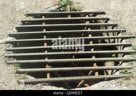 Trou d'homme avec grille. Grille en acier sur le trou dans l'asphalte. Égouts urbains. Banque D'Images