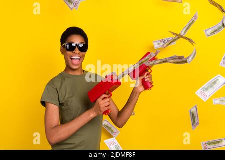 Photo de la personne excitée qui a réussi à tirer des billets de banque usd sourire en dents de souris isolé sur fond jaune Banque D'Images