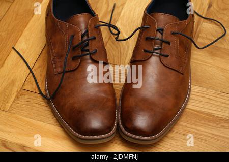 Chaussures en cuir marron pour hommes avec lacets sur le parquet d'une chambre Banque D'Images