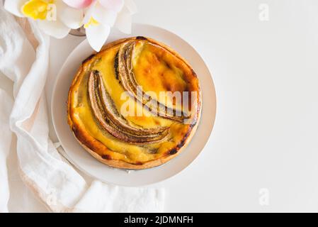 Tarte au cheesecake à la banane sur table blanche Banque D'Images