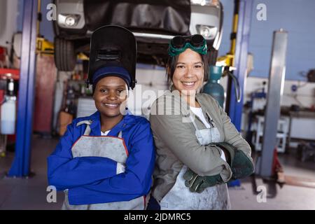 Portrait des soudeurs multiraciaux d'âge moyen, souriants et confiants, travaillant en atelier Banque D'Images