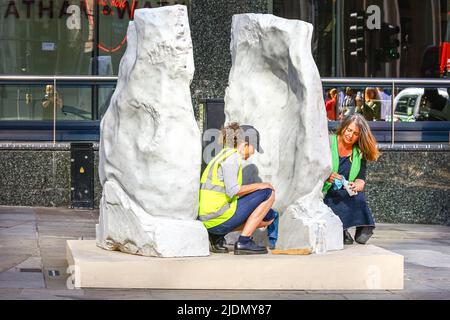 Londres, Royaume-Uni, 22nd juin 2022. Des nettoyants professionnels (modèles fournis par l'organisateur) dans un effort de 'touche finale' avec la sculpture 'Miss' d'Emma Louise Moore. Sculpture in the City, l'exposition annuelle d'art contemporain, lance son édition 11th. Il s'agit d'une exposition d'art en plein air gratuite avec 20 œuvres d'art sont placées à côté de monuments architecturaux contemporains emblématiques tels que le « Gherkin »; Le « Cheesegrater » et la Lloyds of London, ainsi que des espaces nouveaux et historiques au sein de la City tels que Leadenhall Market, et présente de nouvelles œuvres de 11 artistes contemporains. Banque D'Images