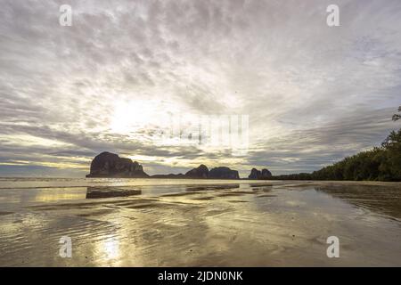 Beau coucher de soleil pittoresque à la plage par.la lumière ombragée dans la mer avec des collines en arrière-plan. Plage de Pak Meng, Trang, Thaïlande Banque D'Images