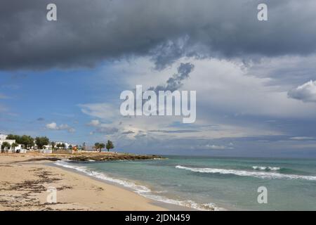 Nuages orageux sur une plage de sable de Salento en Italie. Banque D'Images