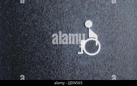 Symbole des toilettes pour personnes handicapées sur le mur noir Banque D'Images