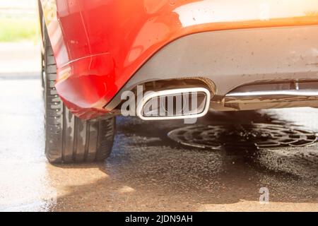 Le tuyau d'échappement est de forme plate sur une voiture rouge Banque D'Images