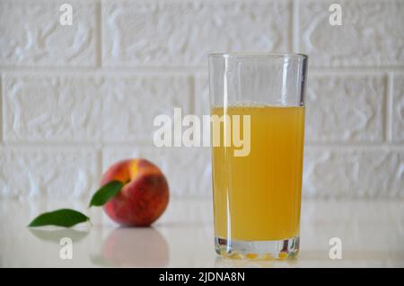 Jus de pêche frais sur fond blanc. Banque D'Images